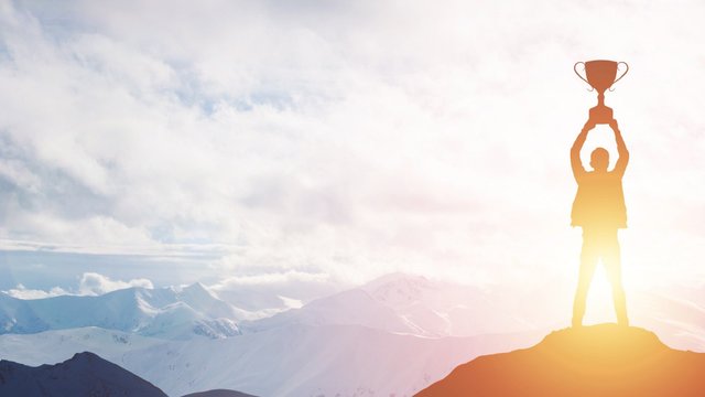 Mann hält Pokal in die Luft
